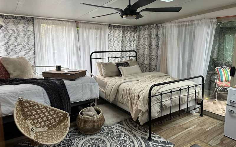 A bedroom with two beds and a ceiling fan.