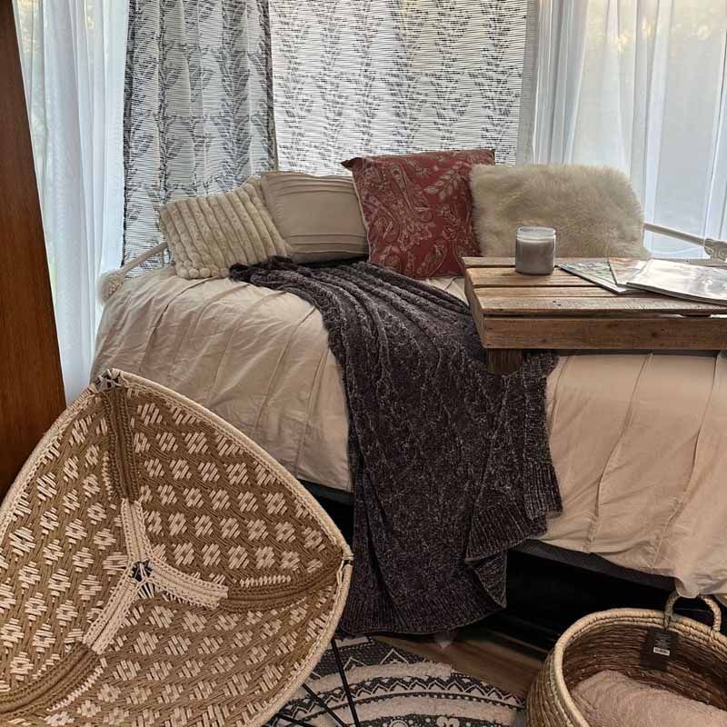 A bed with a tray on top of it and a chair in front of it.