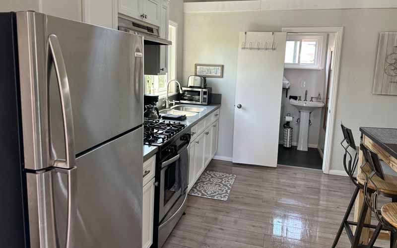 A kitchen with a refrigerator , stove , sink and microwave.
