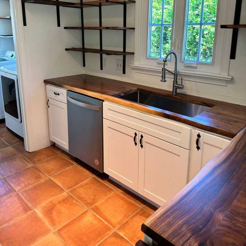 A kitchen with white cabinets and a stainless steel dishwasher