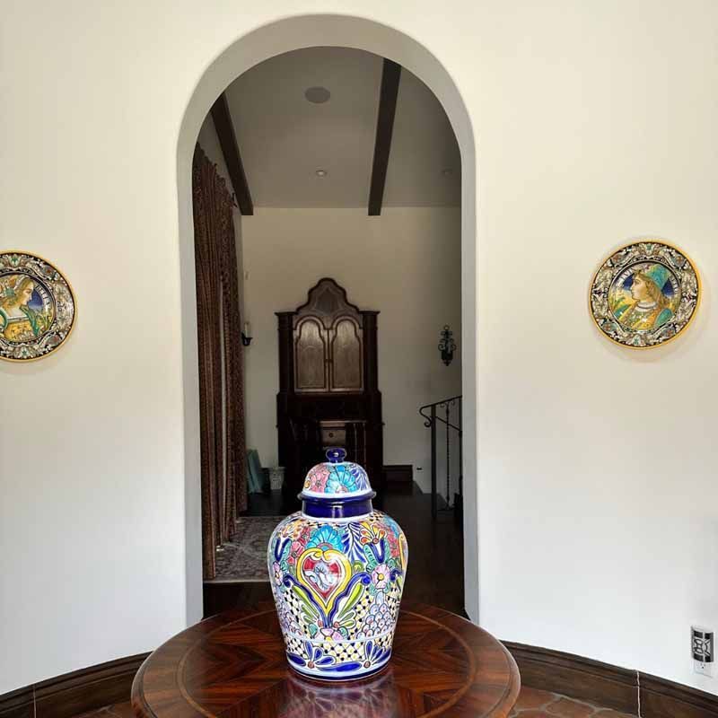 A colorful vase sits on a wooden table in a room