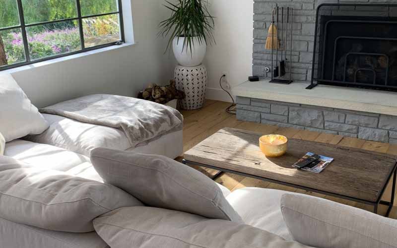 A living room with a couch , coffee table and fireplace.