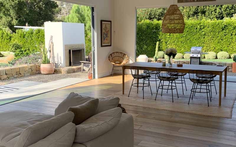 A living room with a couch , table , chairs and a fireplace.
