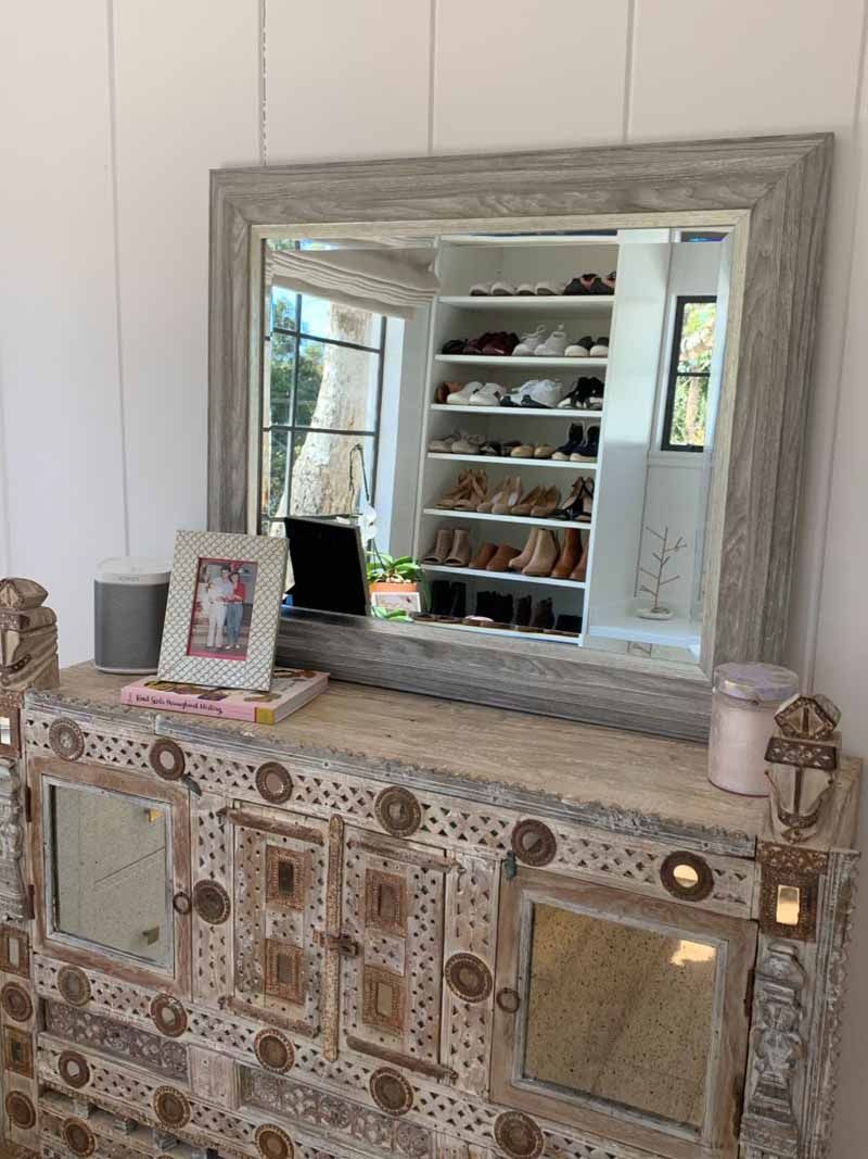 A large mirror is sitting on top of a dresser in a room.