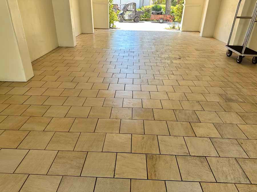 A tiled floor in a room with a cart in the background.