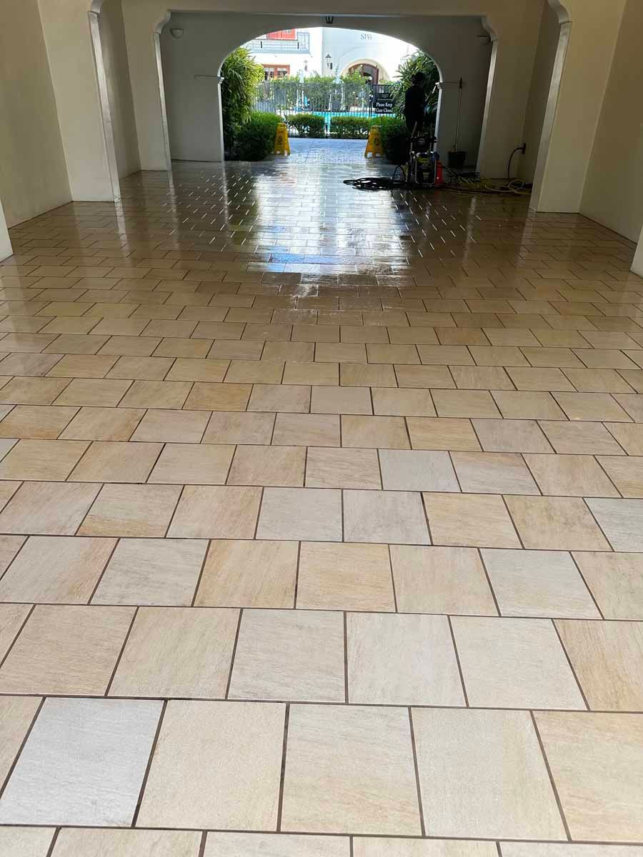A tiled floor in a building with a doorway leading to a garden.