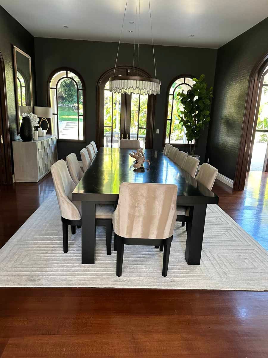 A large dining room with a long table and chairs.