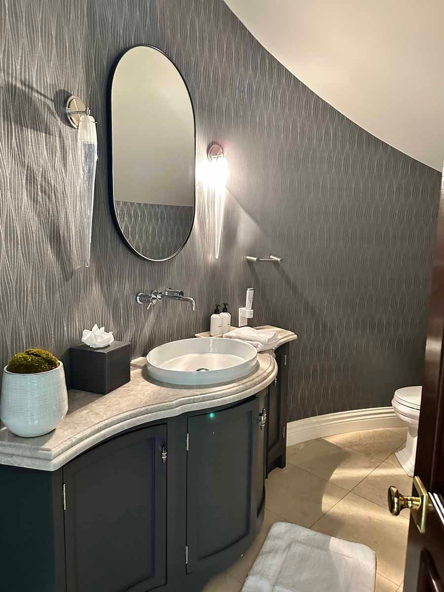A bathroom with a sink , mirror and toilet.