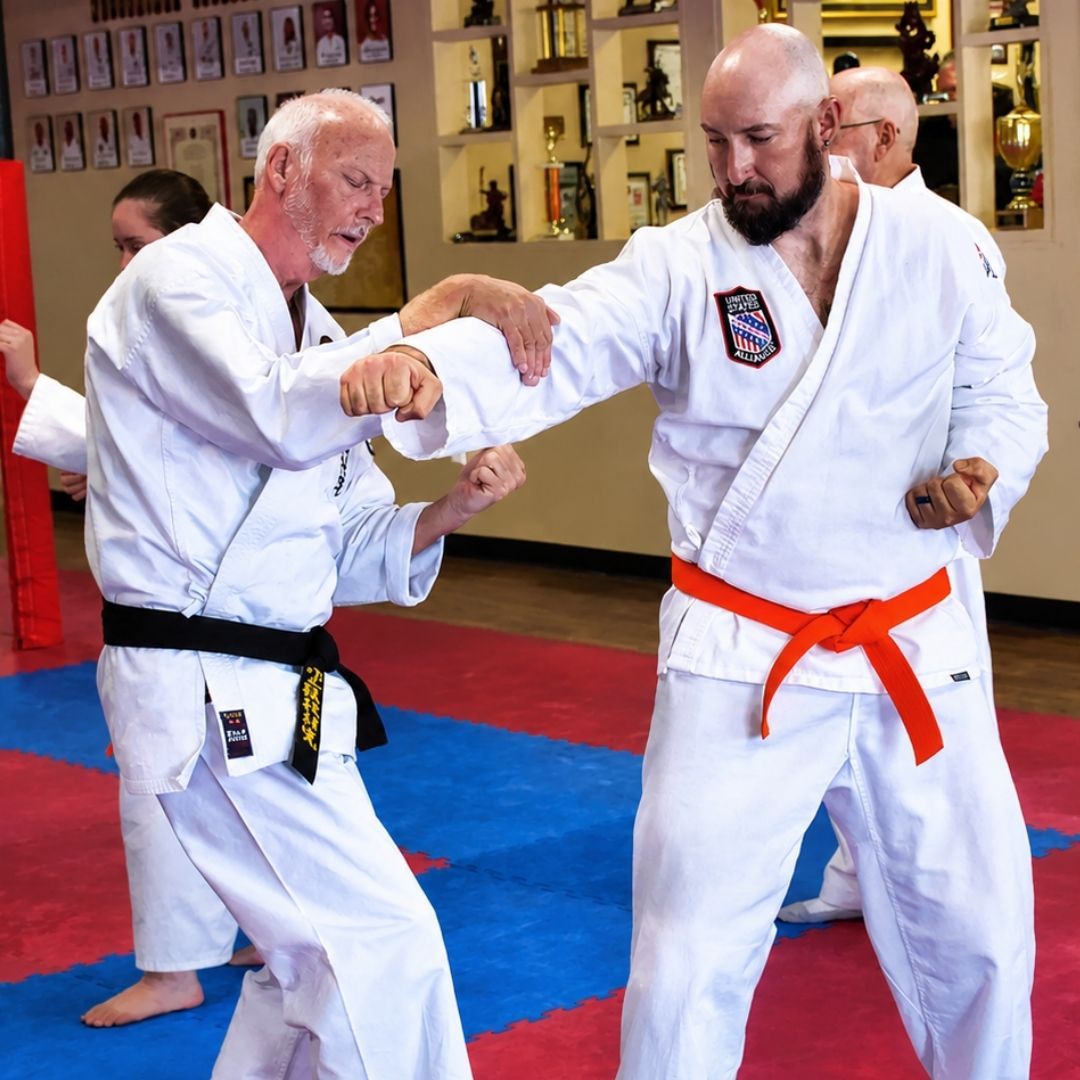 Two men grappling on a mat, one in blue, the other in black.