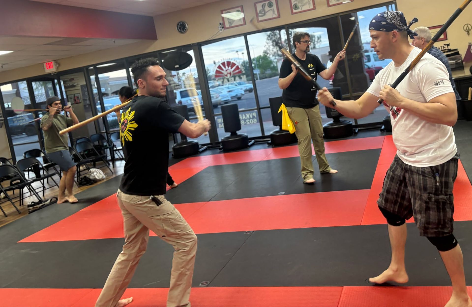 Group of children in martial arts attire posing, some with arms around each other, in a gym.