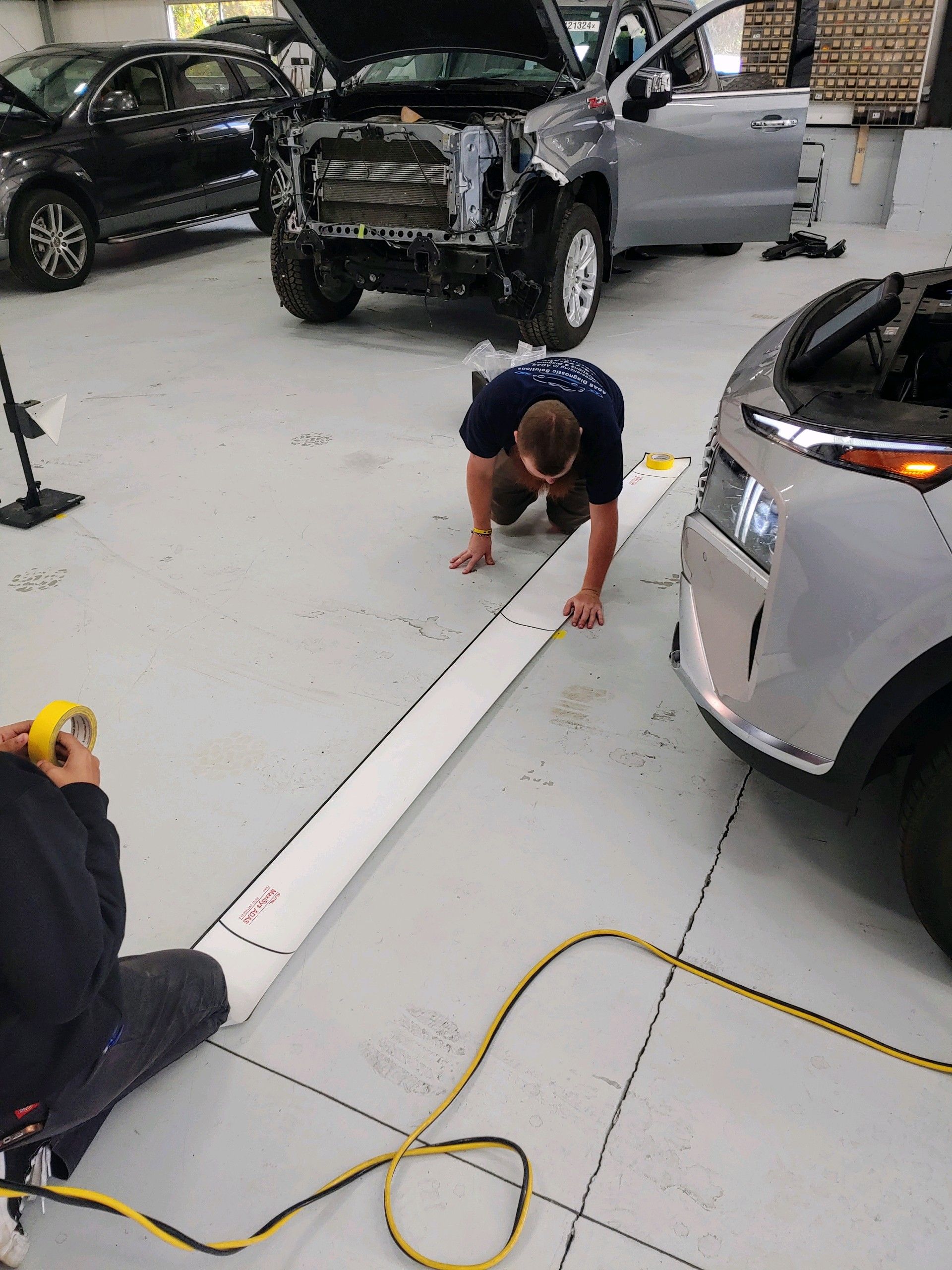 A black and white photo of a row of cars parked in a parking lot.