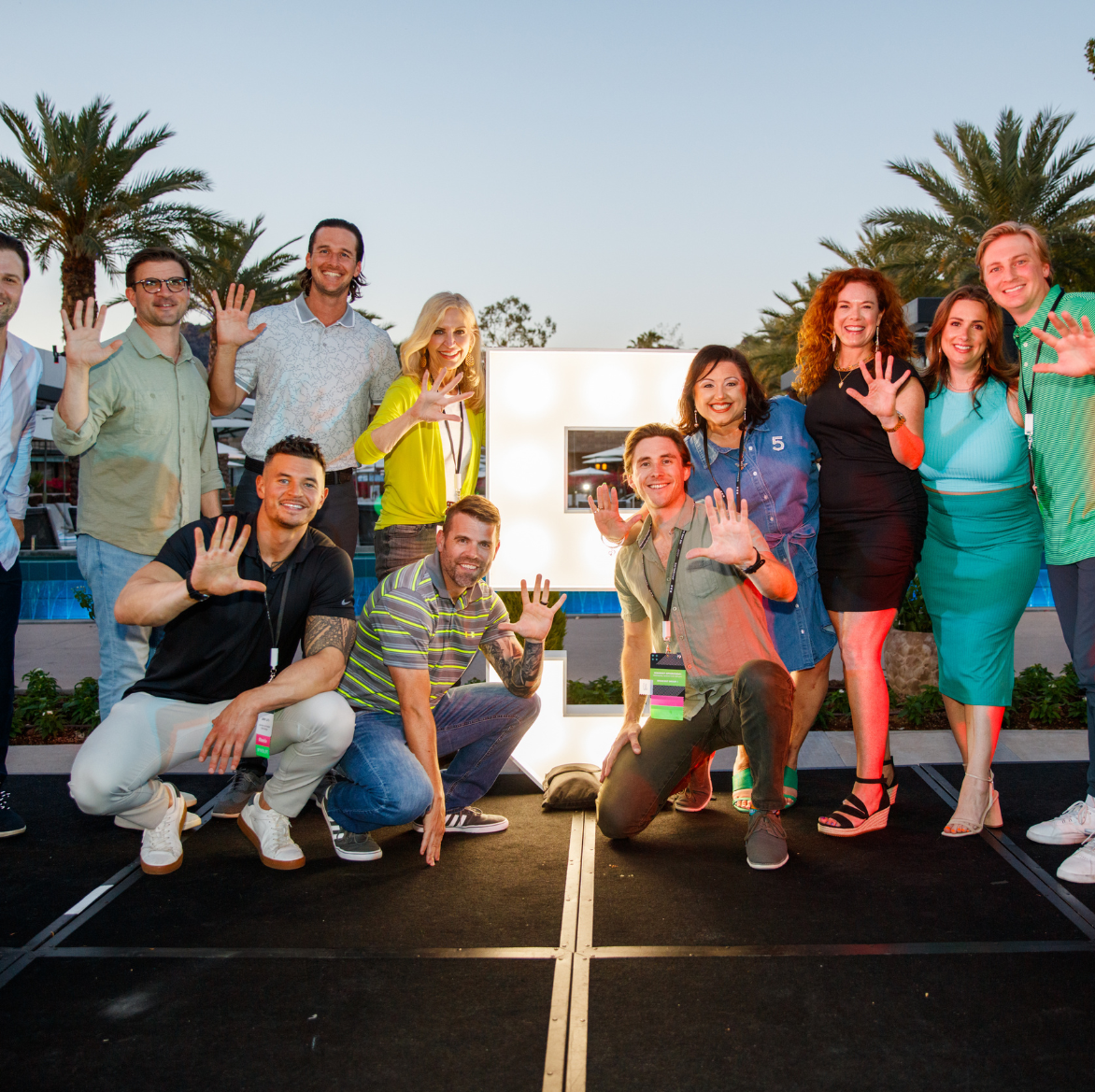 A group of people posing in front of a large letter e