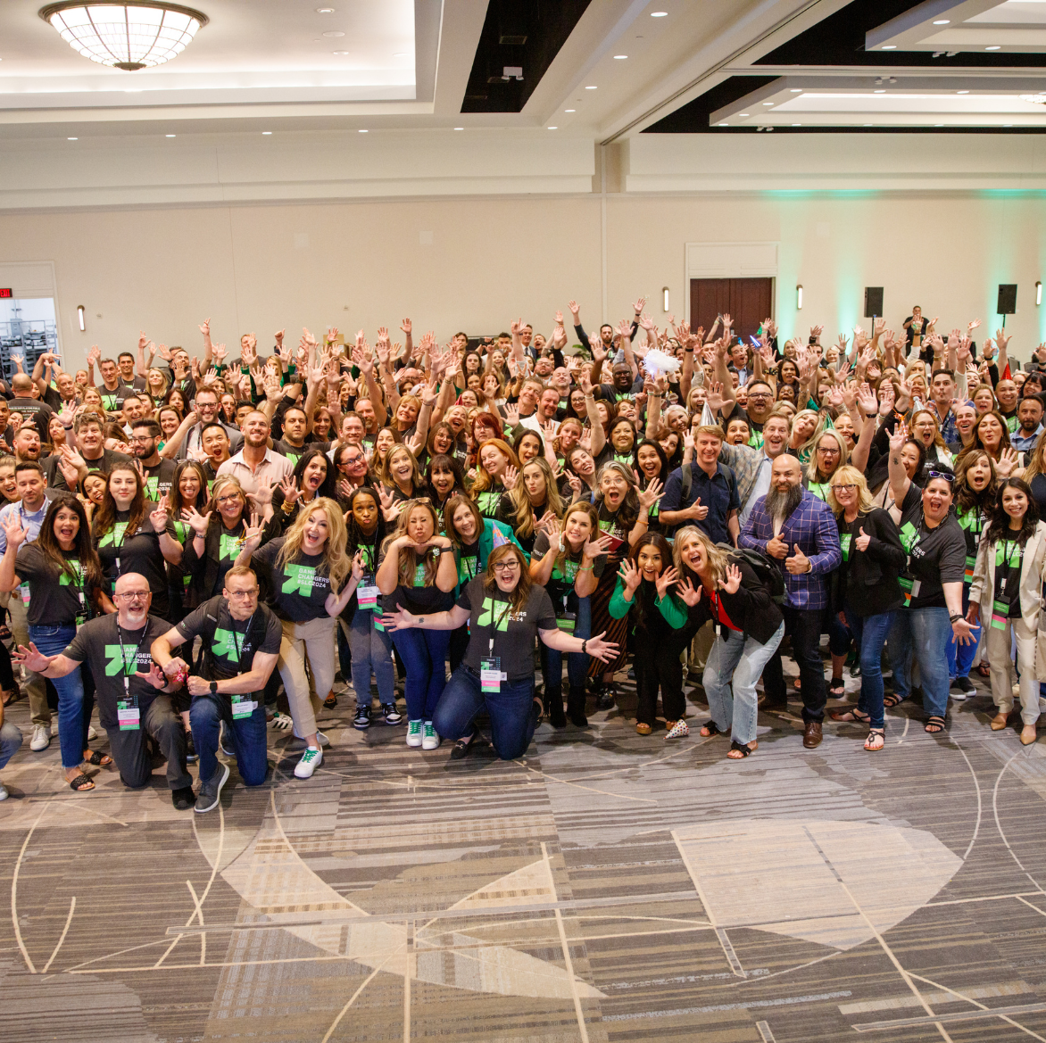 A large group of people are posing for a picture in a large room.