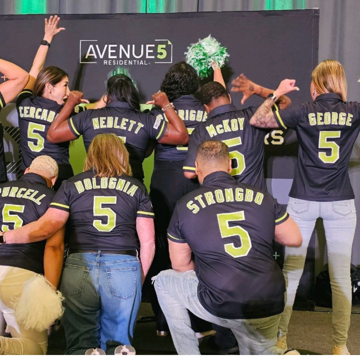 A group of people wearing black shirts with the number 5 on them