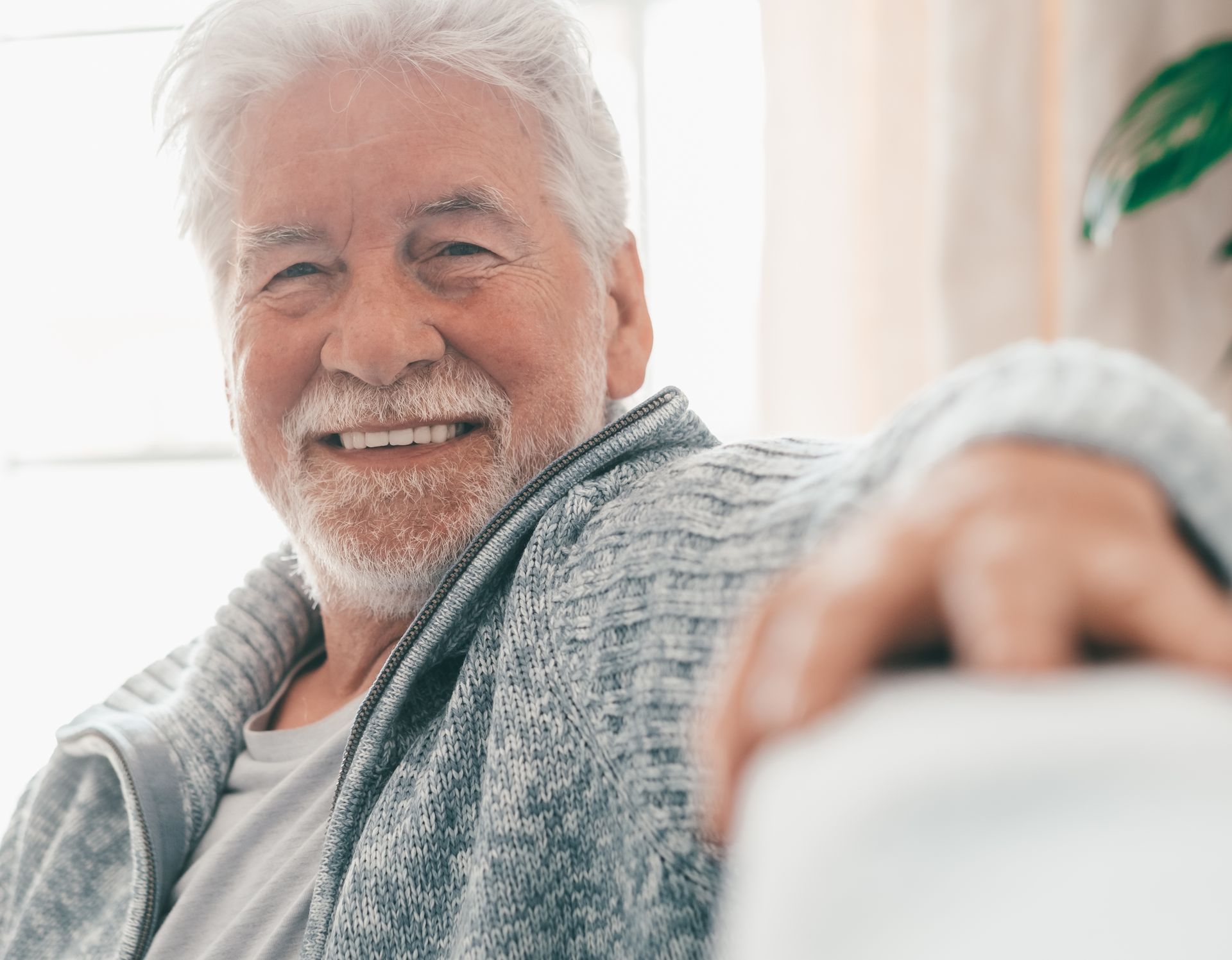 A man is covering his ears while a woman sleeps next to him.