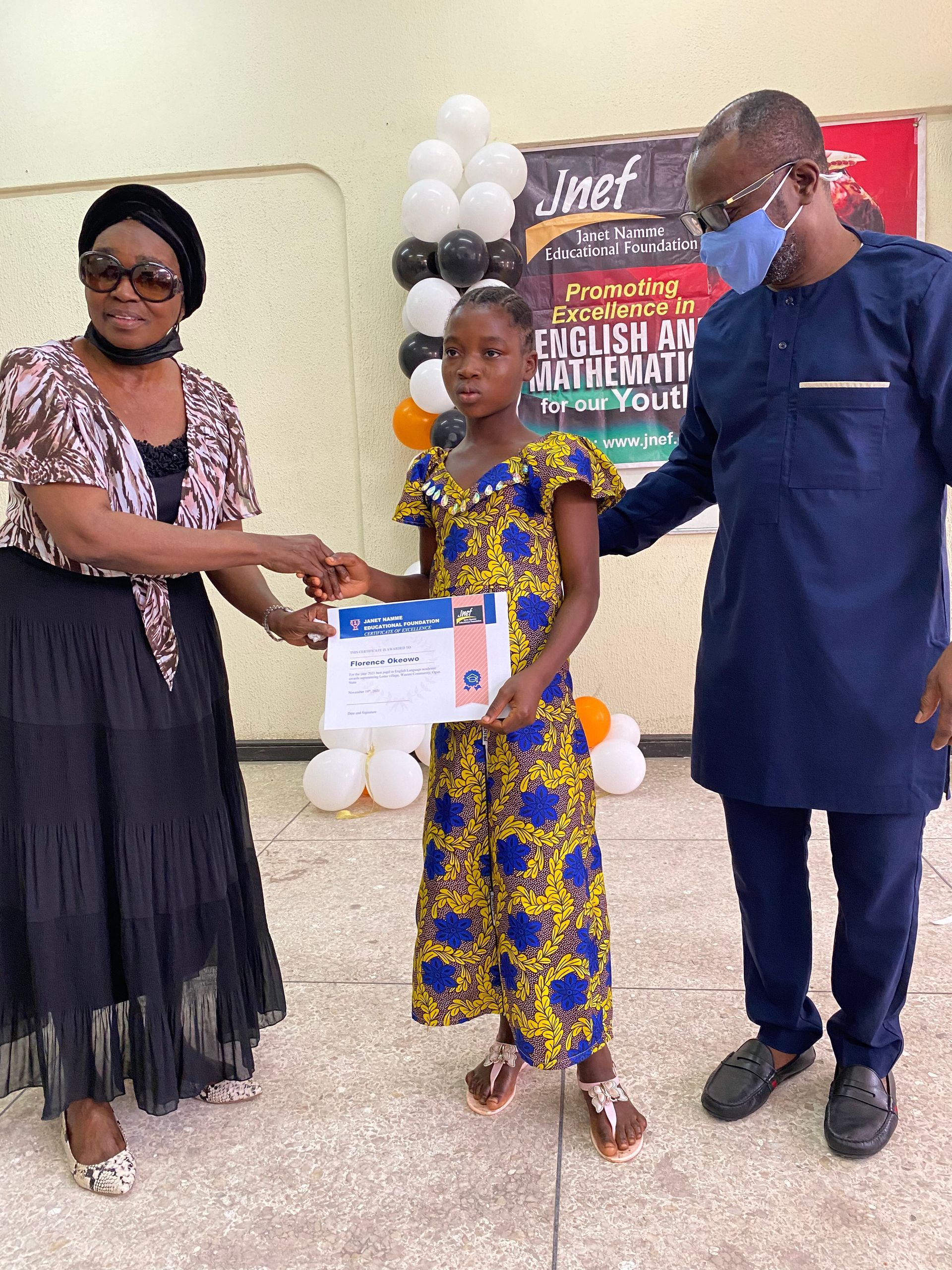 A woman is giving a certificate to a little girl