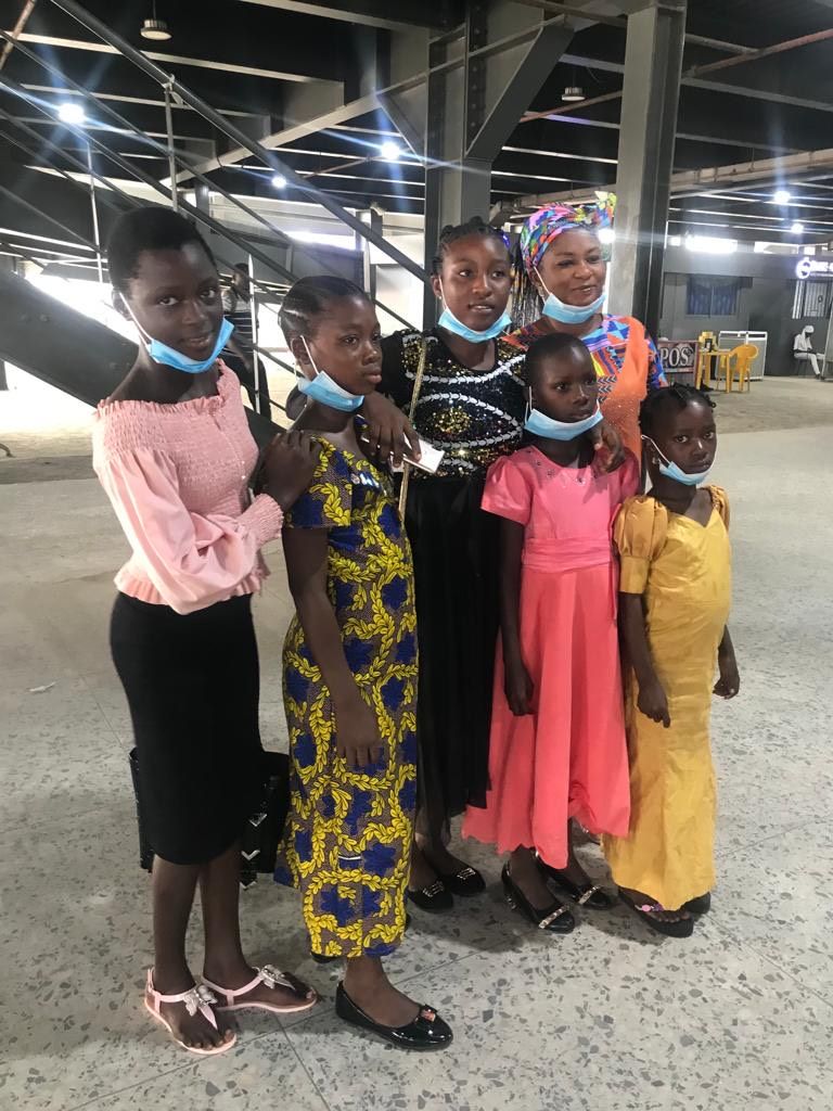 A group of young girls wearing face masks are posing for a picture.