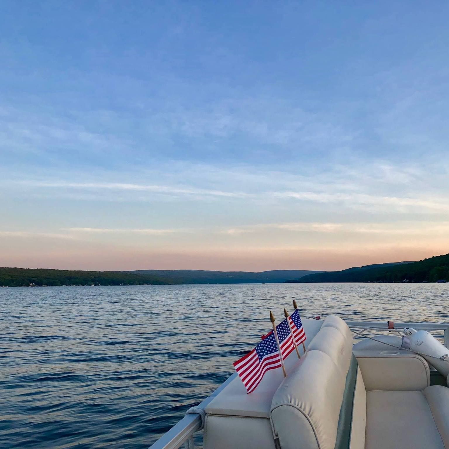 A boat on a lake with american flags on the back