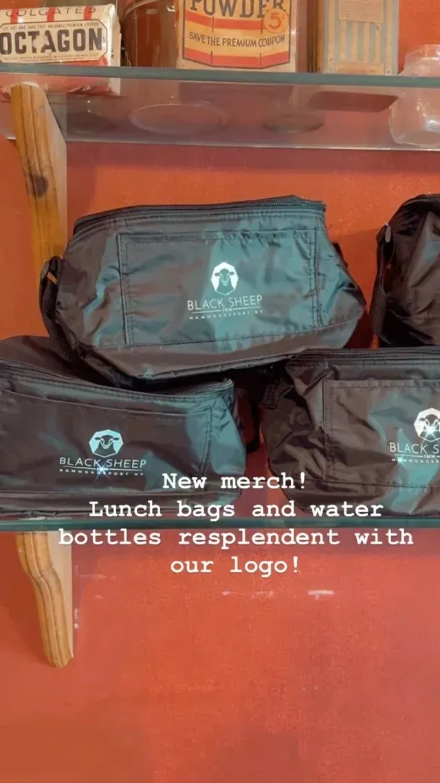 A stack of lunch bags and water bottles on a glass shelf.