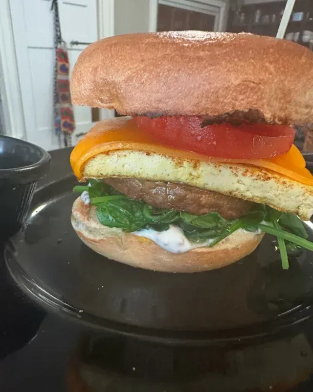 A close up of a hamburger on a plate on a stove.