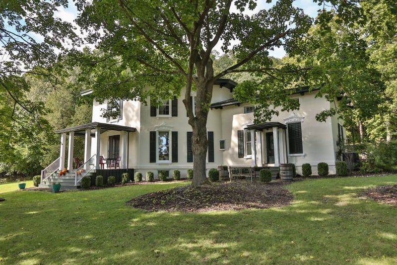 A large white house with a tree in front of it