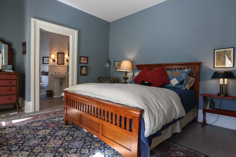 A bedroom with blue walls and a wooden bed