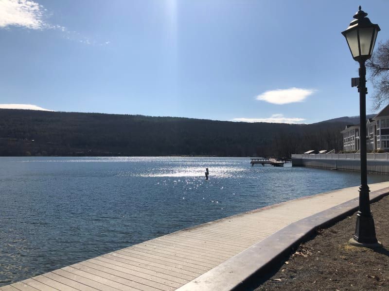 A lake with a dock and a lamp post in the foreground