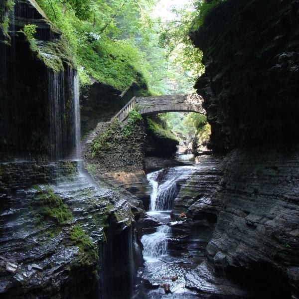 A bridge over a river with a waterfall in the background