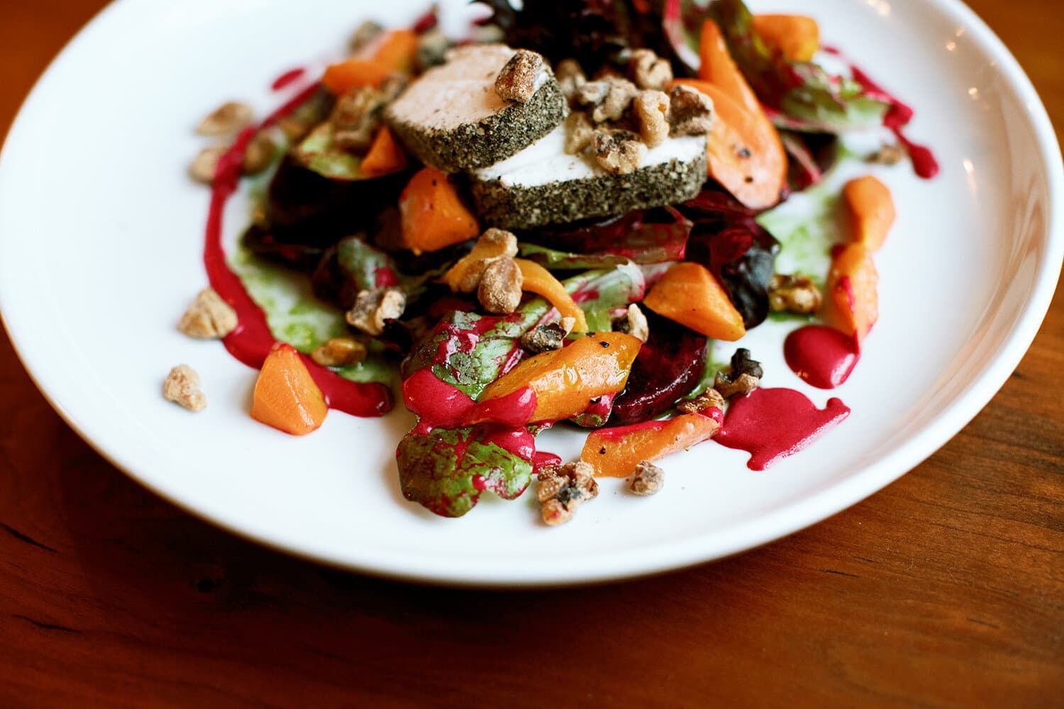 A close up of a plate of food on a wooden table.