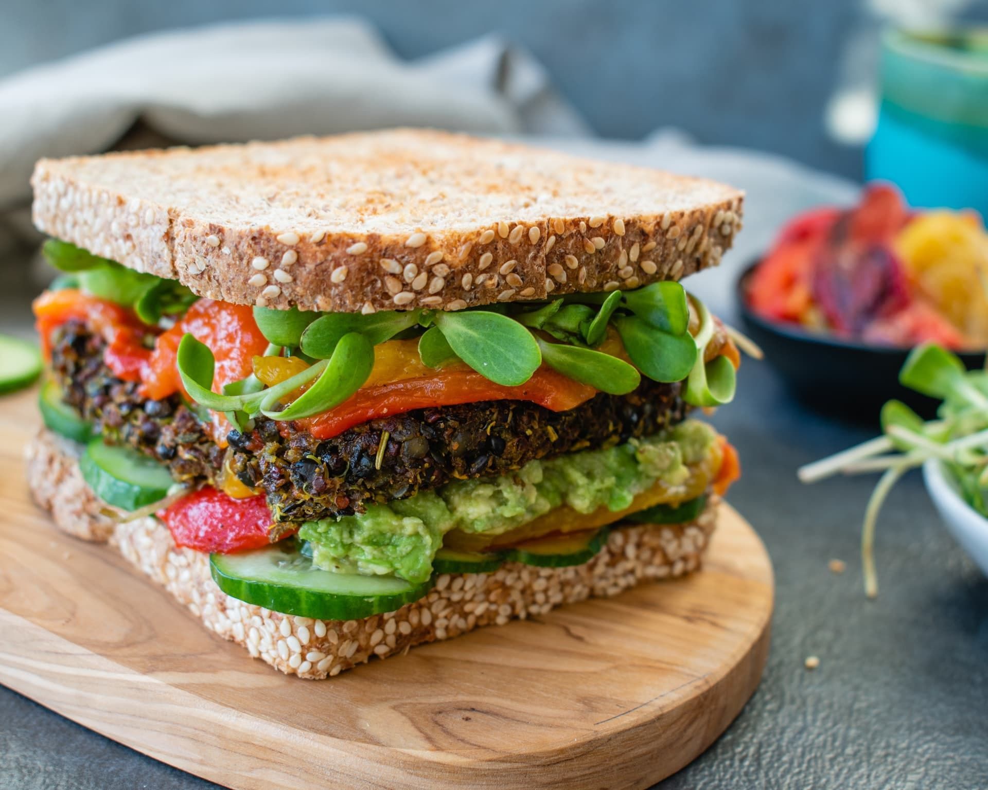 A close up of a sandwich on a wooden cutting board.