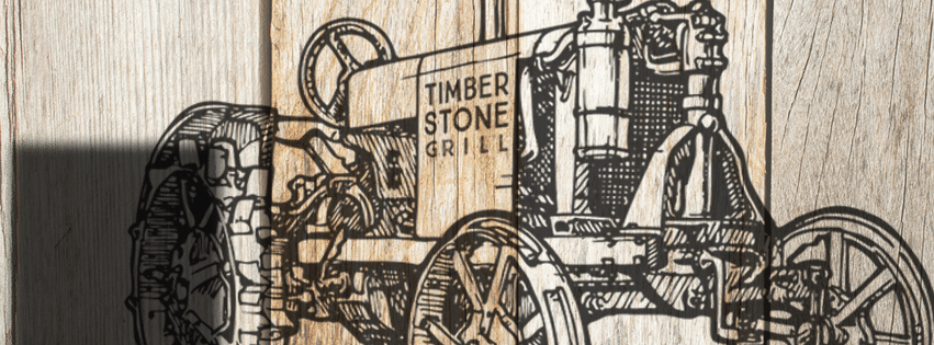 A black and white drawing of an old tractor on a wooden wall.