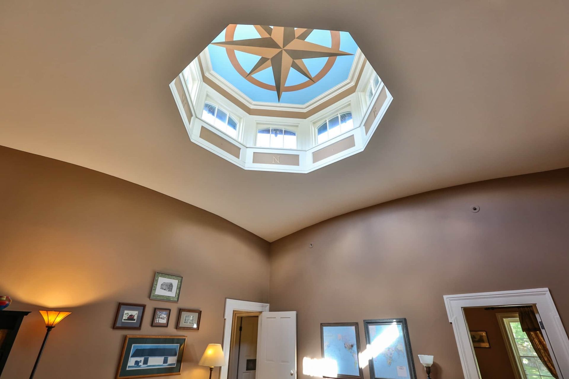 A living room with a skylight and a compass on the ceiling