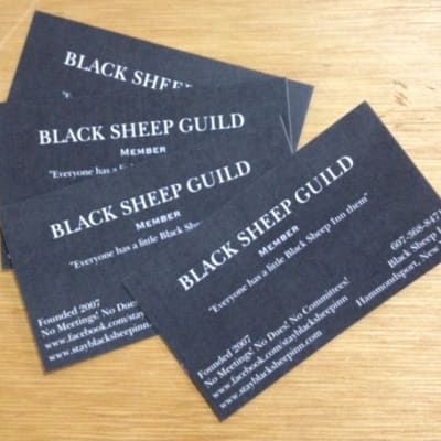 A stack of black sheep guild business cards