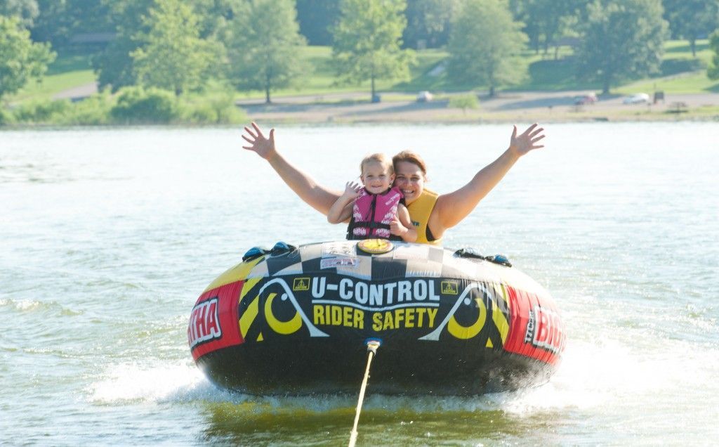 Two people smiling in a yellow inflatable tube on a lake, with arms raised and a U-Change safety logo.