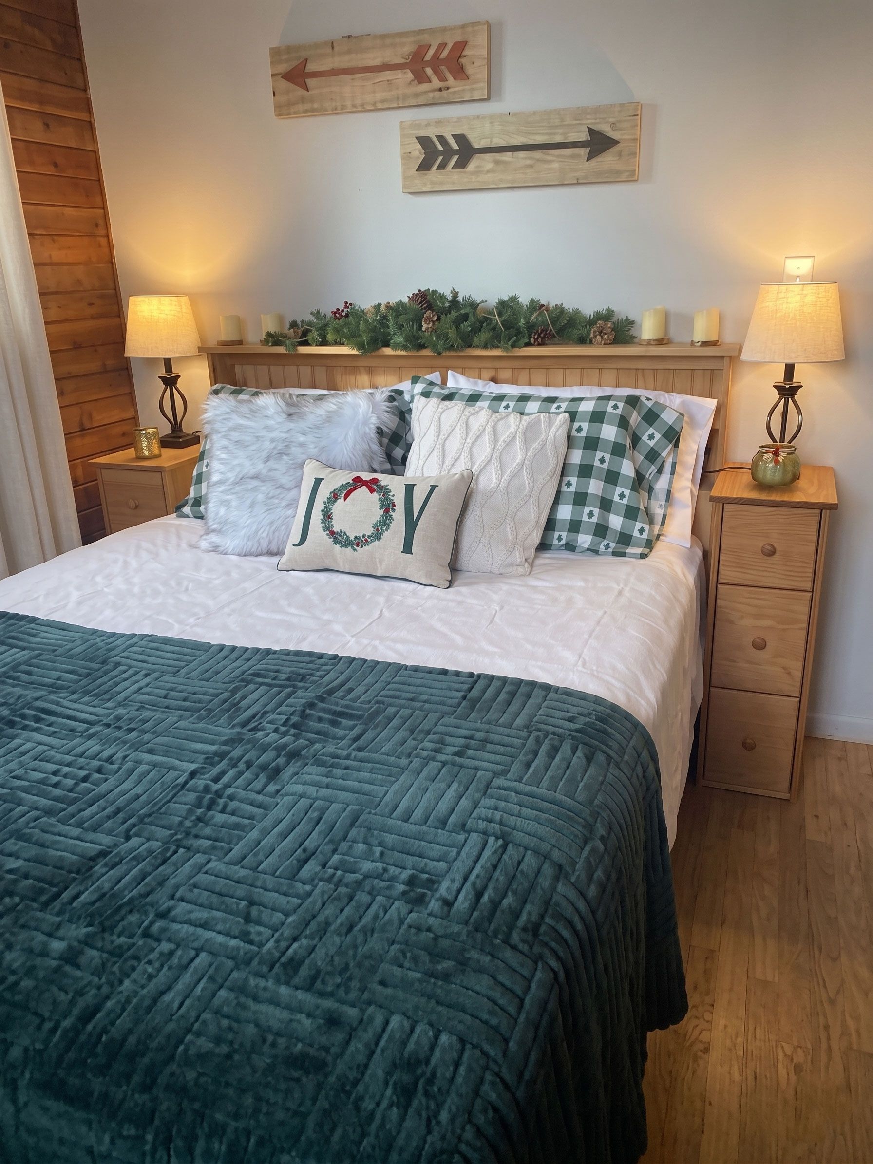 Cozy bedroom with teal quilt, patterned pillows, wooden nightstands, lamps, and wall art