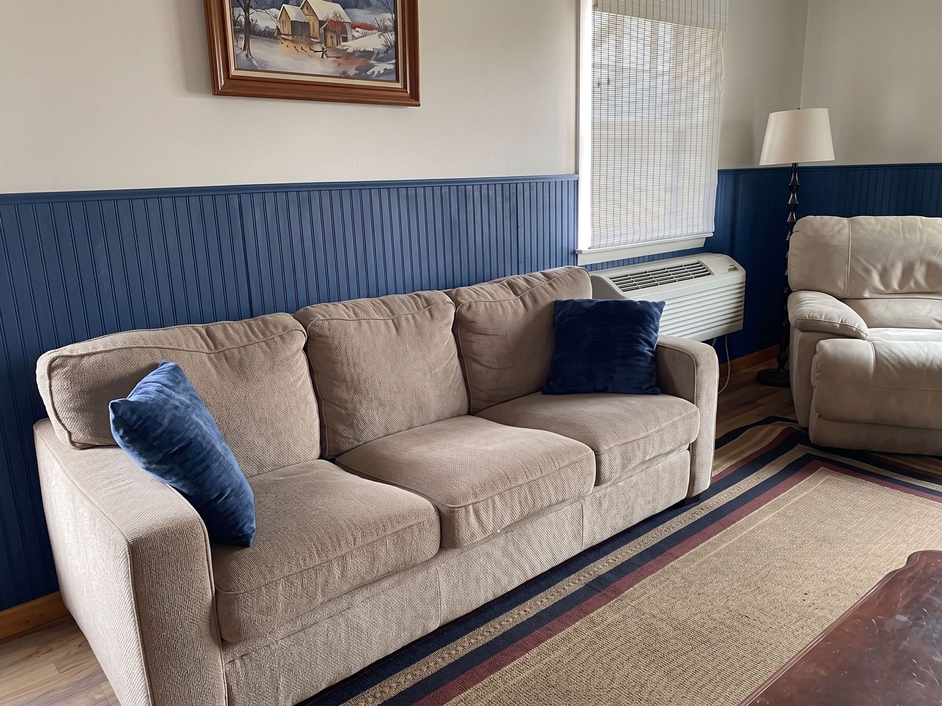 Living room with beige sofa, blue pillows, and patterned blue wall paneling