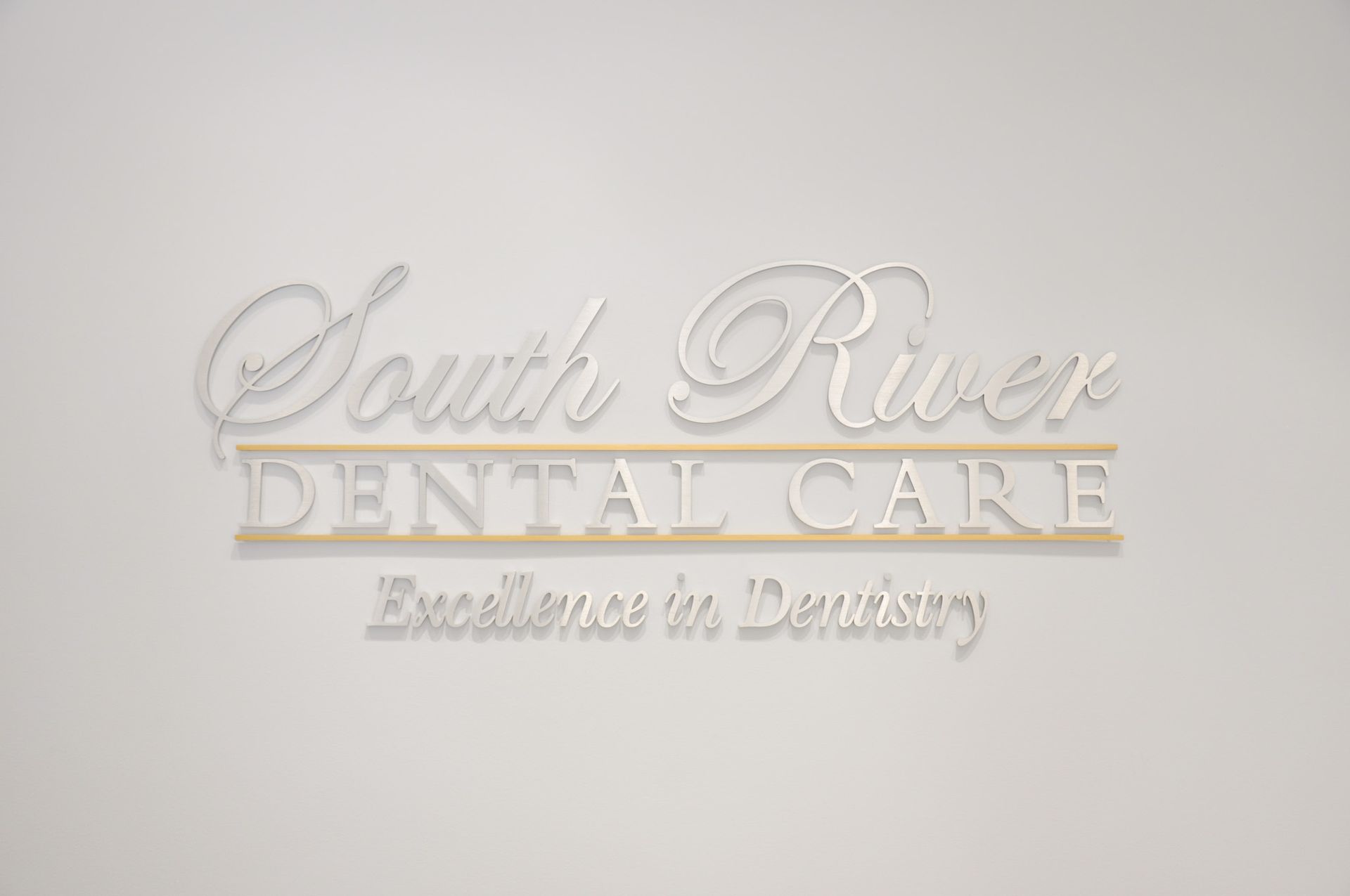 South River Dental Care logo on a wall, with text 