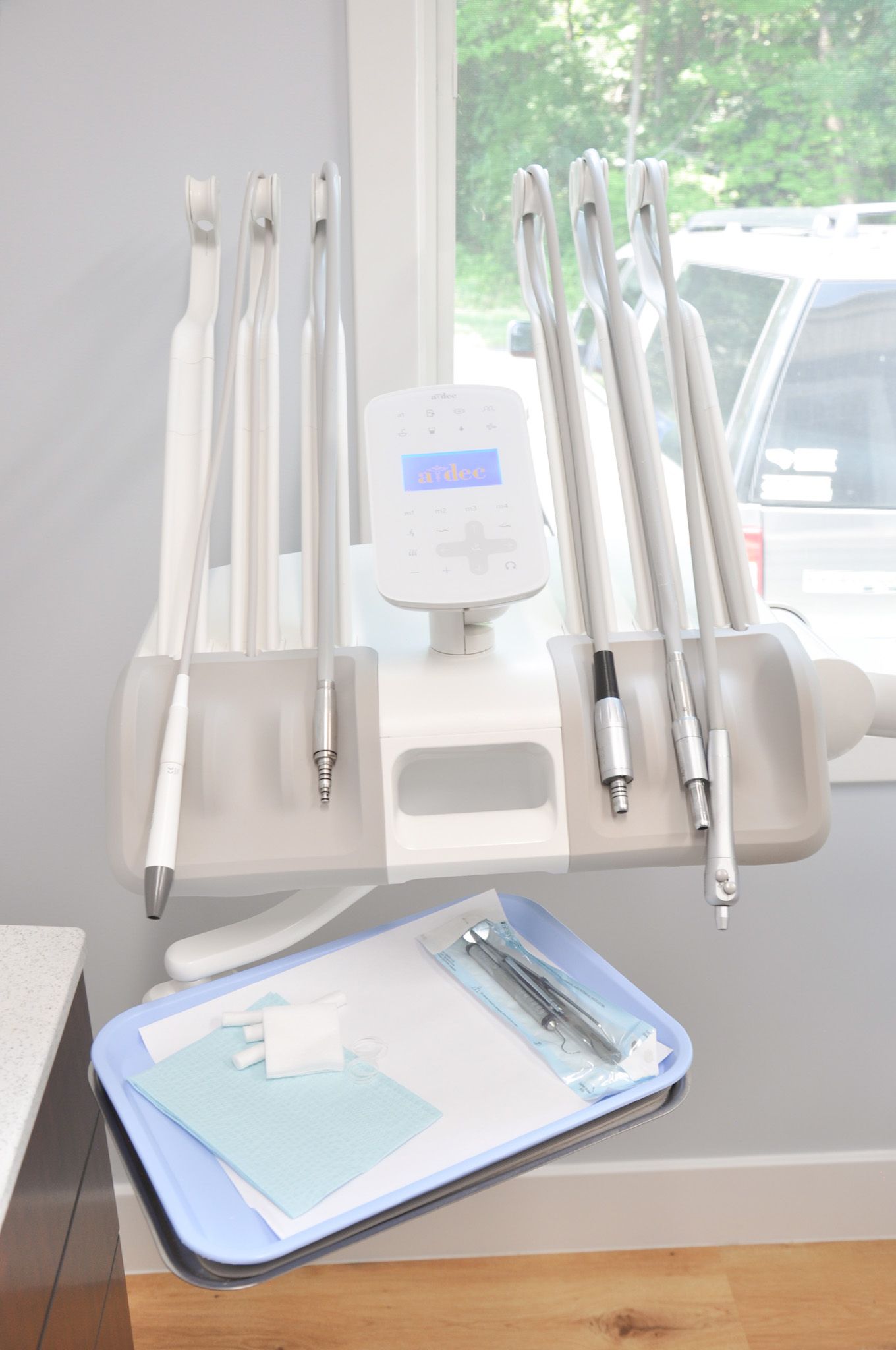 Dental chair arm with tools and tray of supplies.