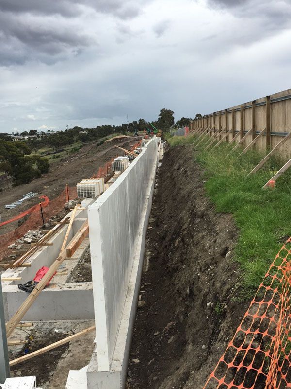 A concrete wall is being built on top of a dirt hill.