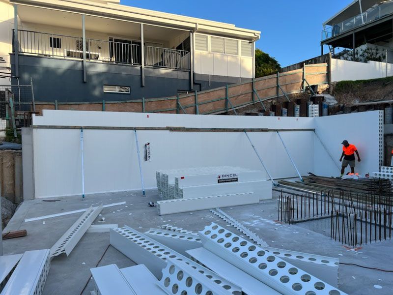 A man is standing in front of a building under construction.