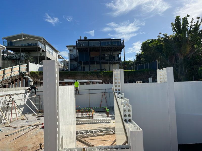 A construction site with a large house in the background.