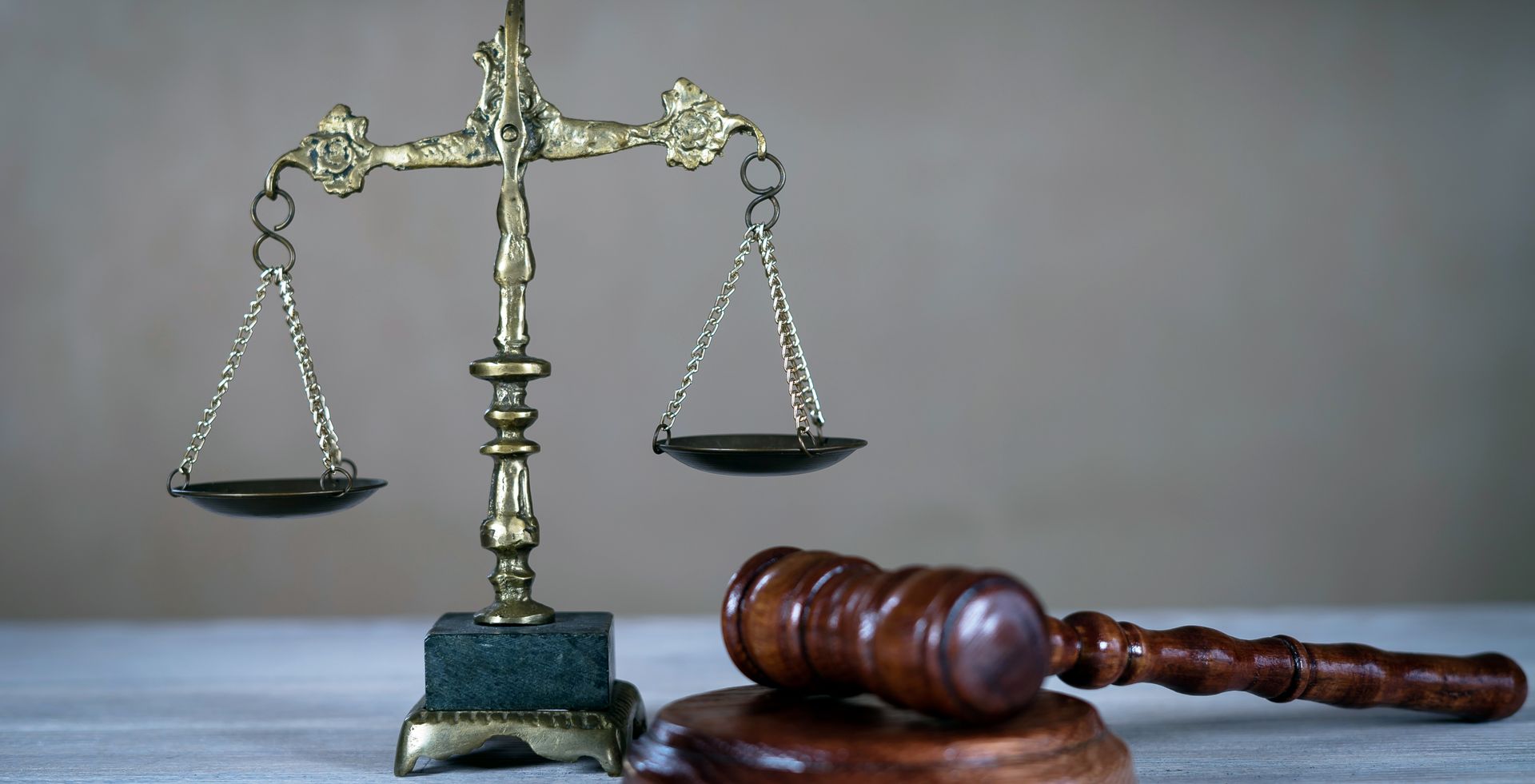 A scale of justice and a judge 's gavel are on a table.