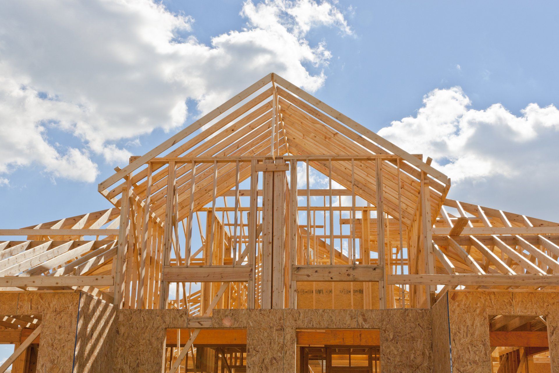 Your dream home. New residential construction house framing against a blue sky.