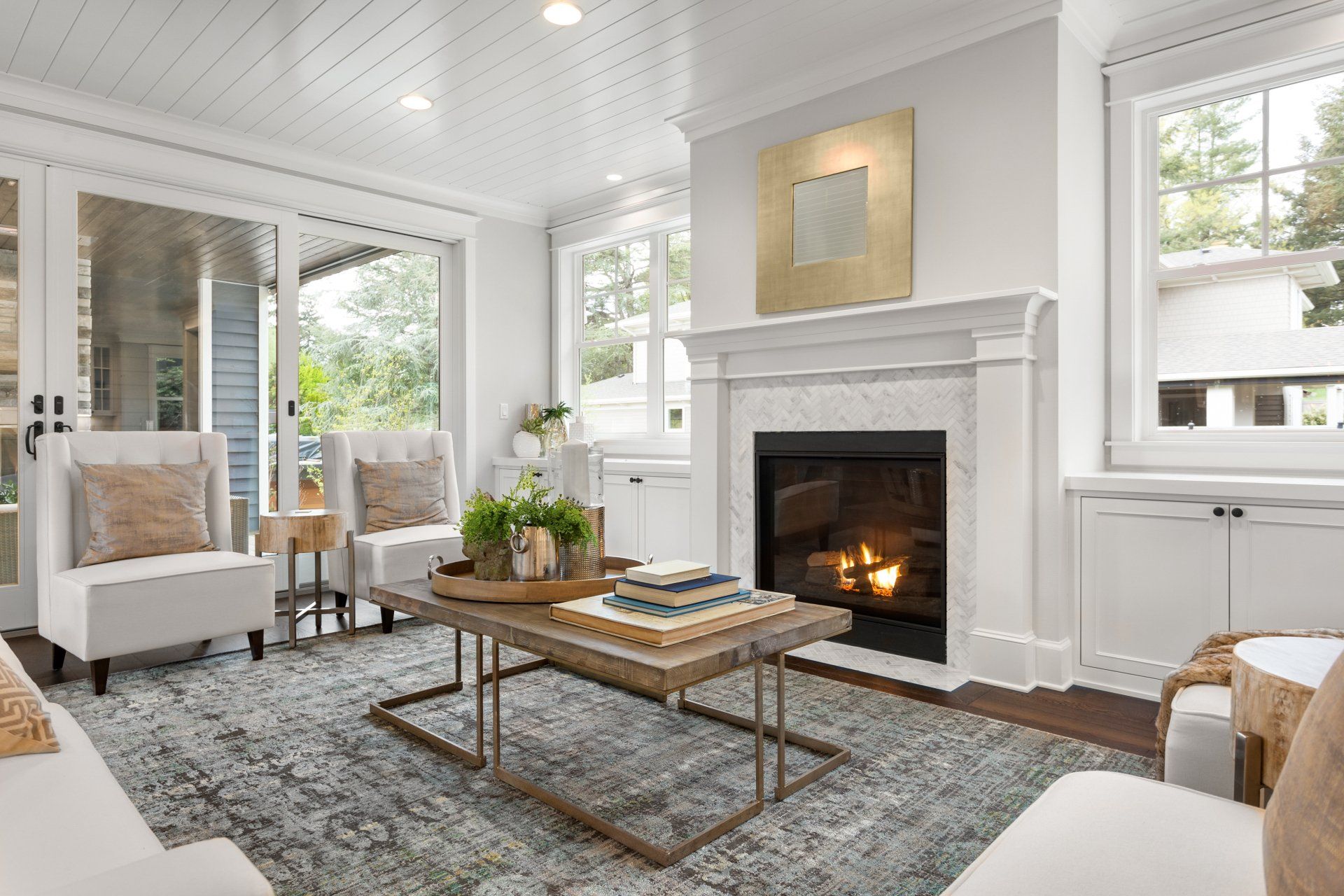 Beautiful white living room in new luxury home with white interior. Has fire in fireplace