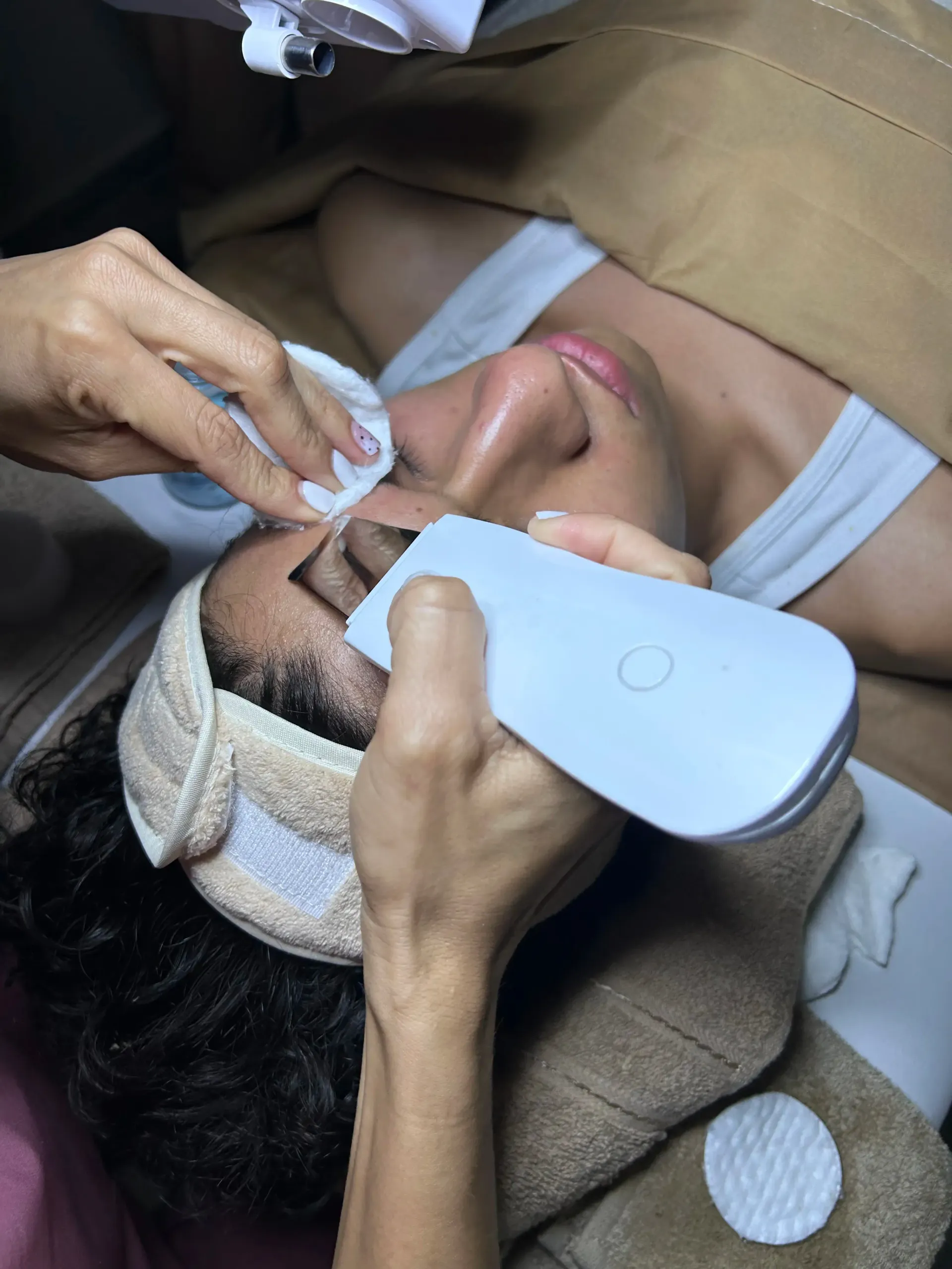 Una mujer recibe un tratamiento facial en un salón de belleza.