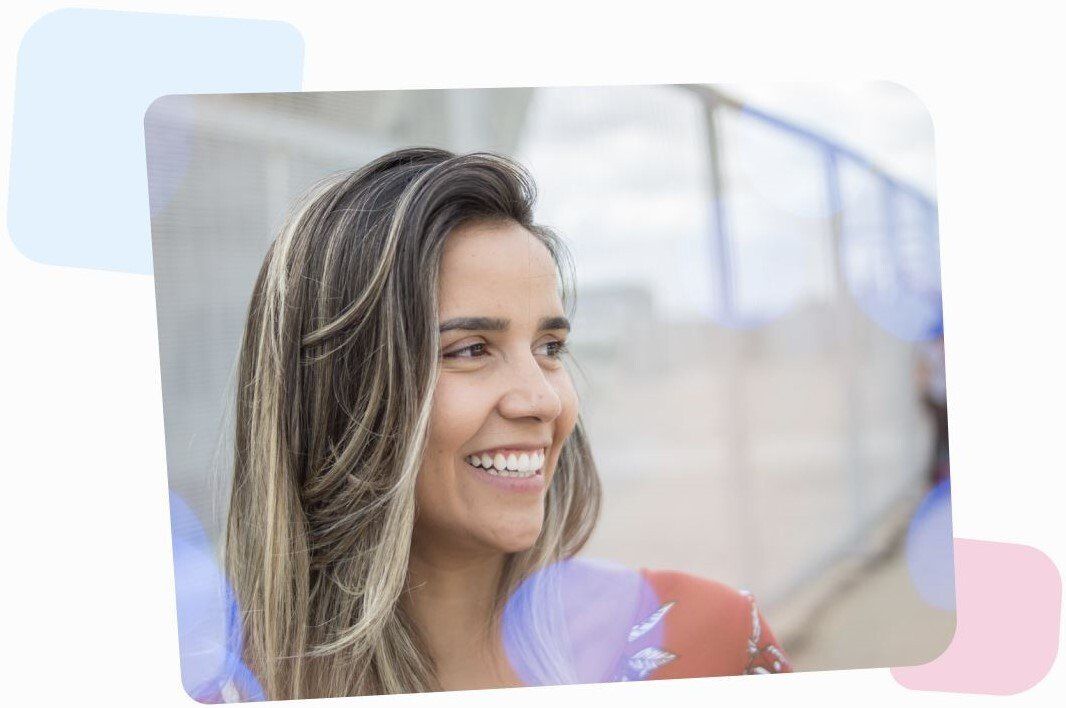 smiling woman staying outside, looking in the distance on the right