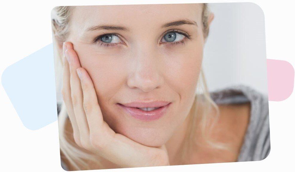 thoughtful blonde woman holding her head in her right arm looking behind the camera