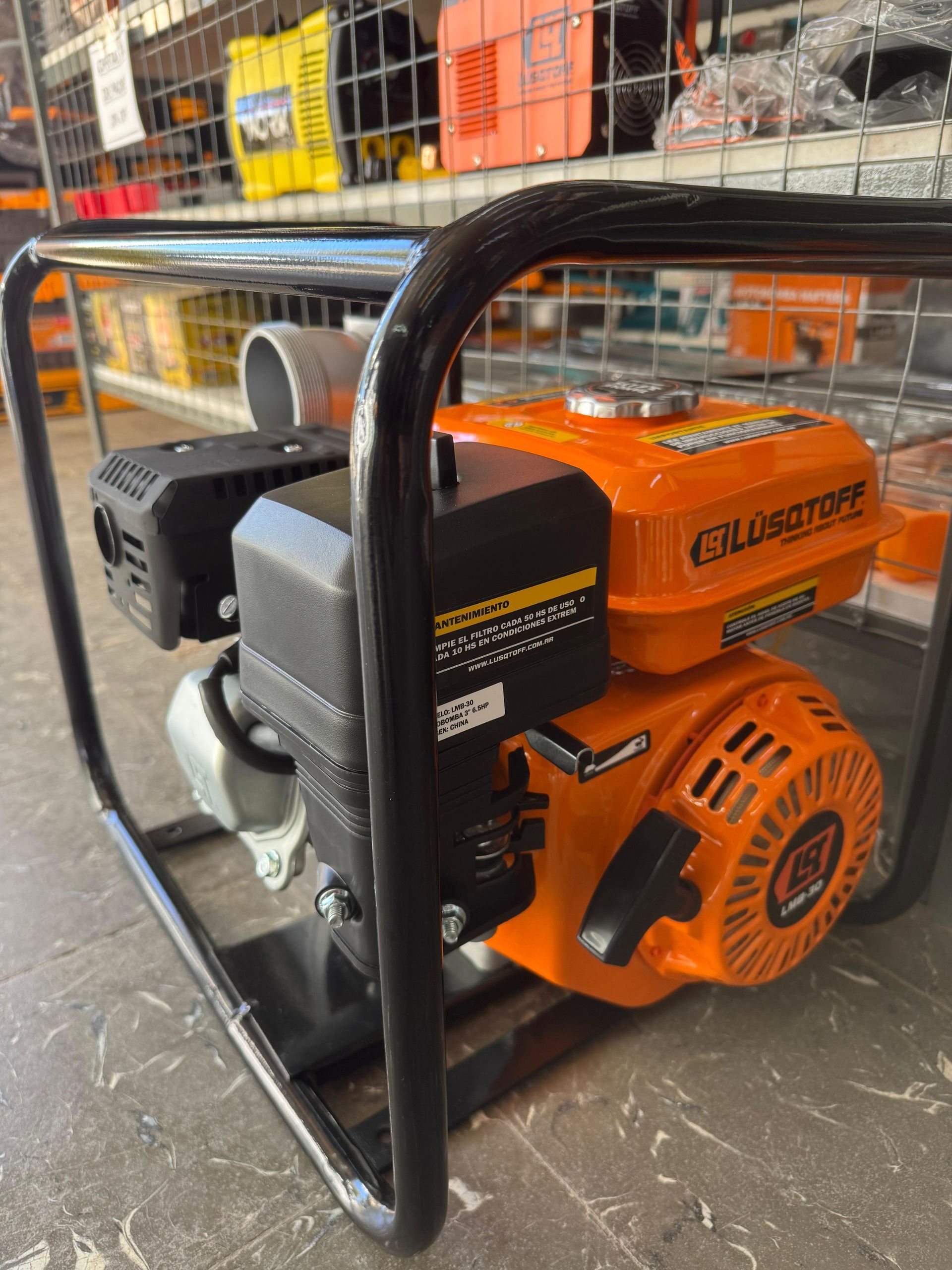 Bomba de agua de color naranja y negro con marco de metal negro, para interior.