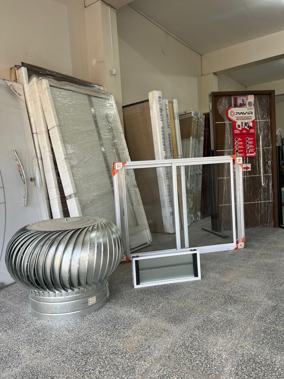 Interior de tienda con puertas, ventanas y ventilador.