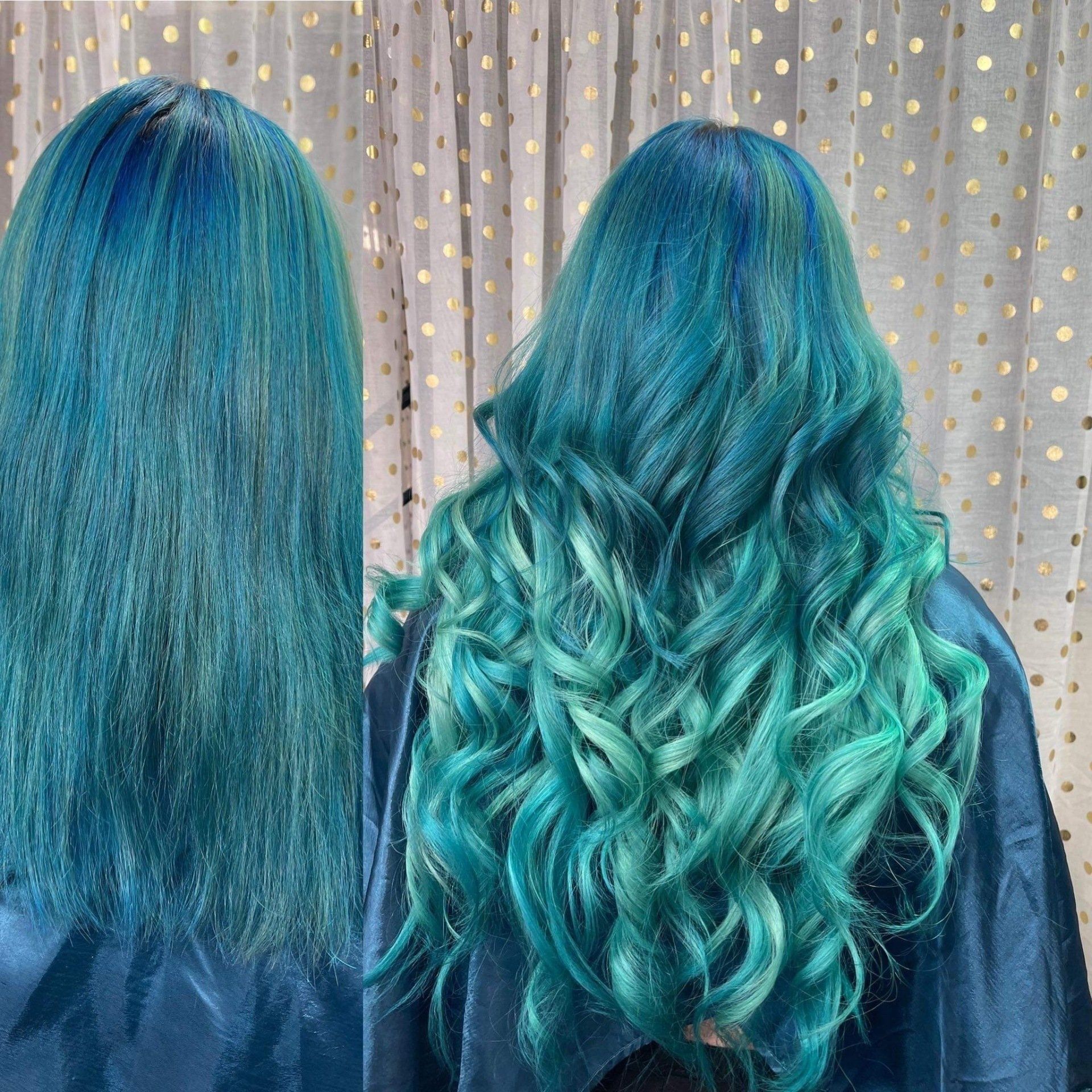 A woman with blue and green hair is standing in front of a white curtain.